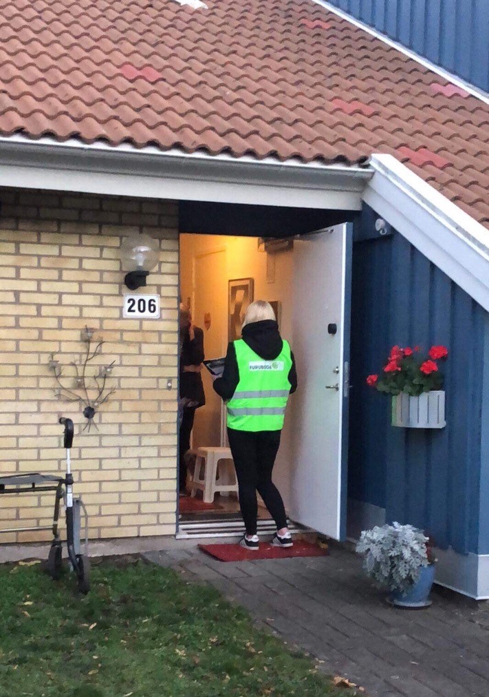 En person med Furuboda-väst står i en dörröppning