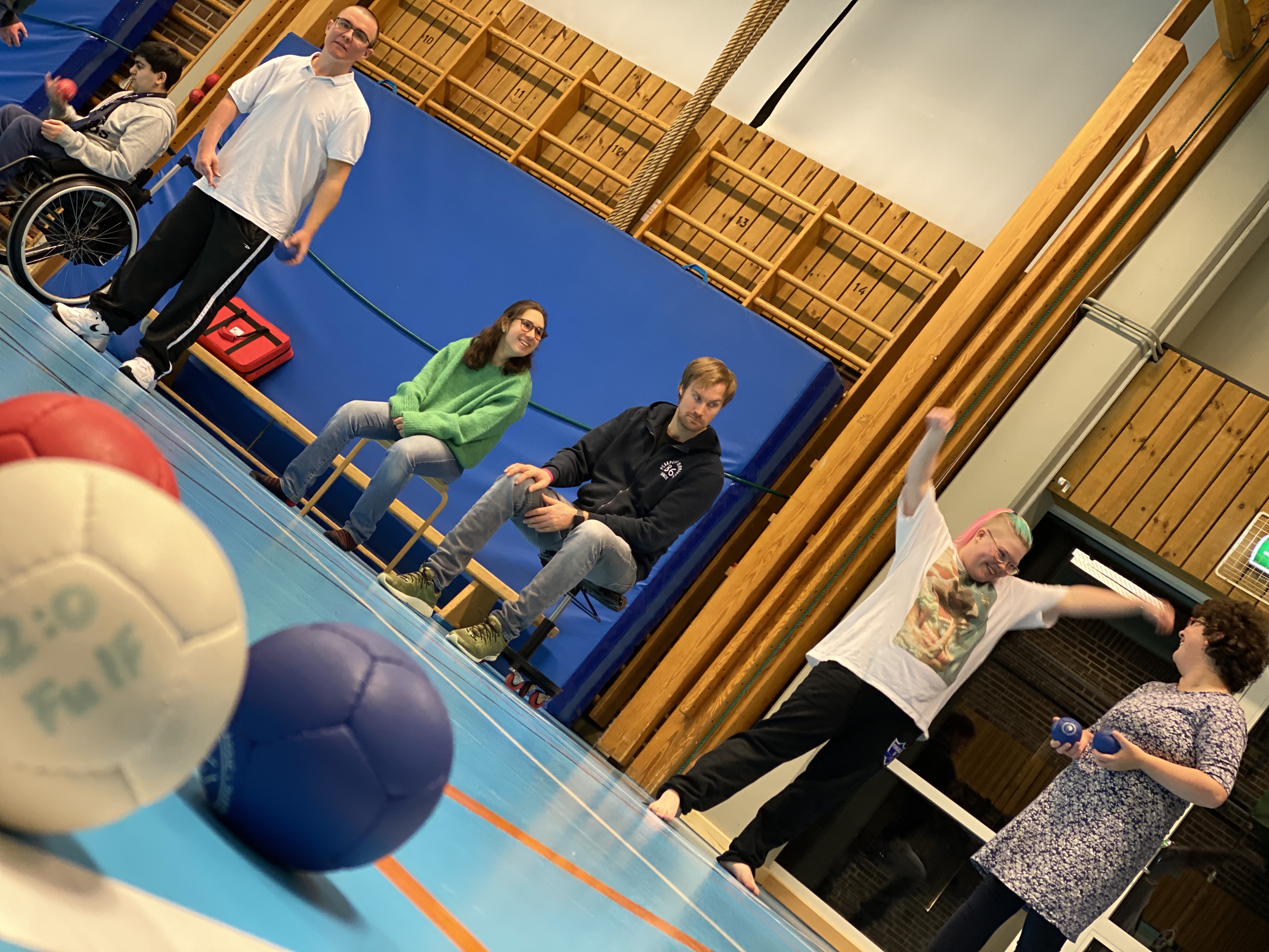 En grupp människor spelar boccia i en sporthall 