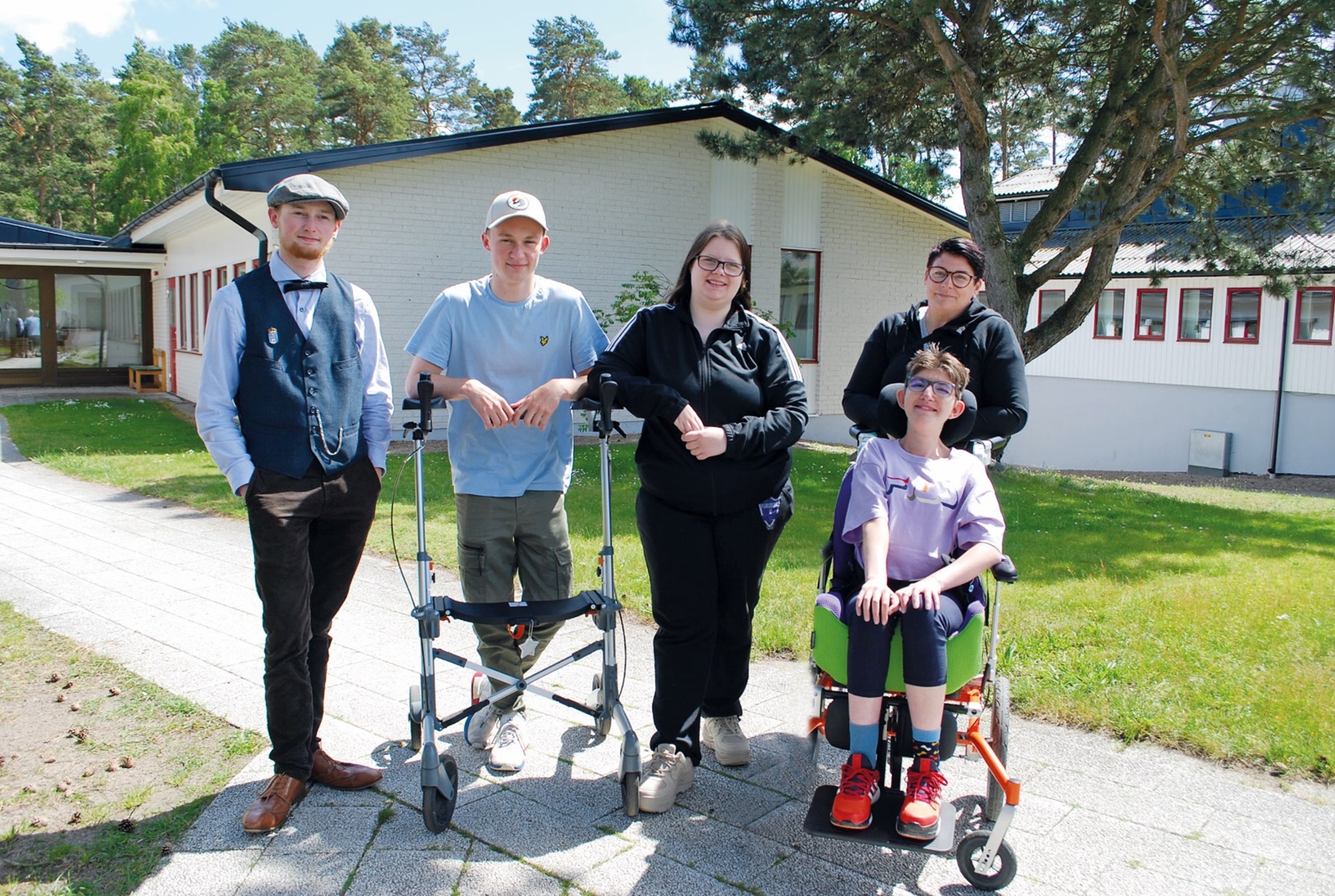 Fem personer poserar leendes för ett foto på Furuboda Yngsjös innegård.