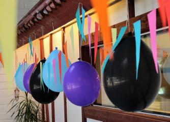 Upphängda girlanger och ballonger i blått lila och svart