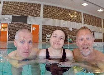 Tre personer i en simbassäng