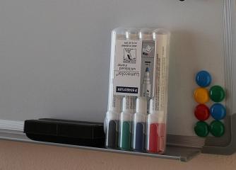 En whiteboardtavla med pennor och magneter